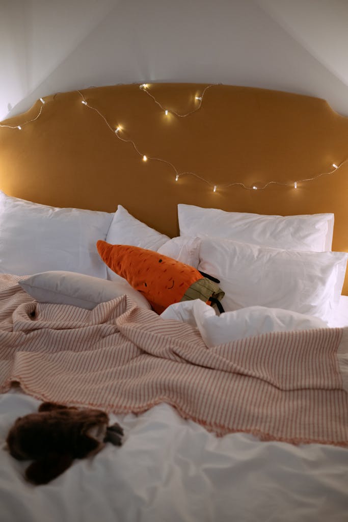 A welcoming bedroom scene with warm fairy lights and a carrot-shaped plush toy.